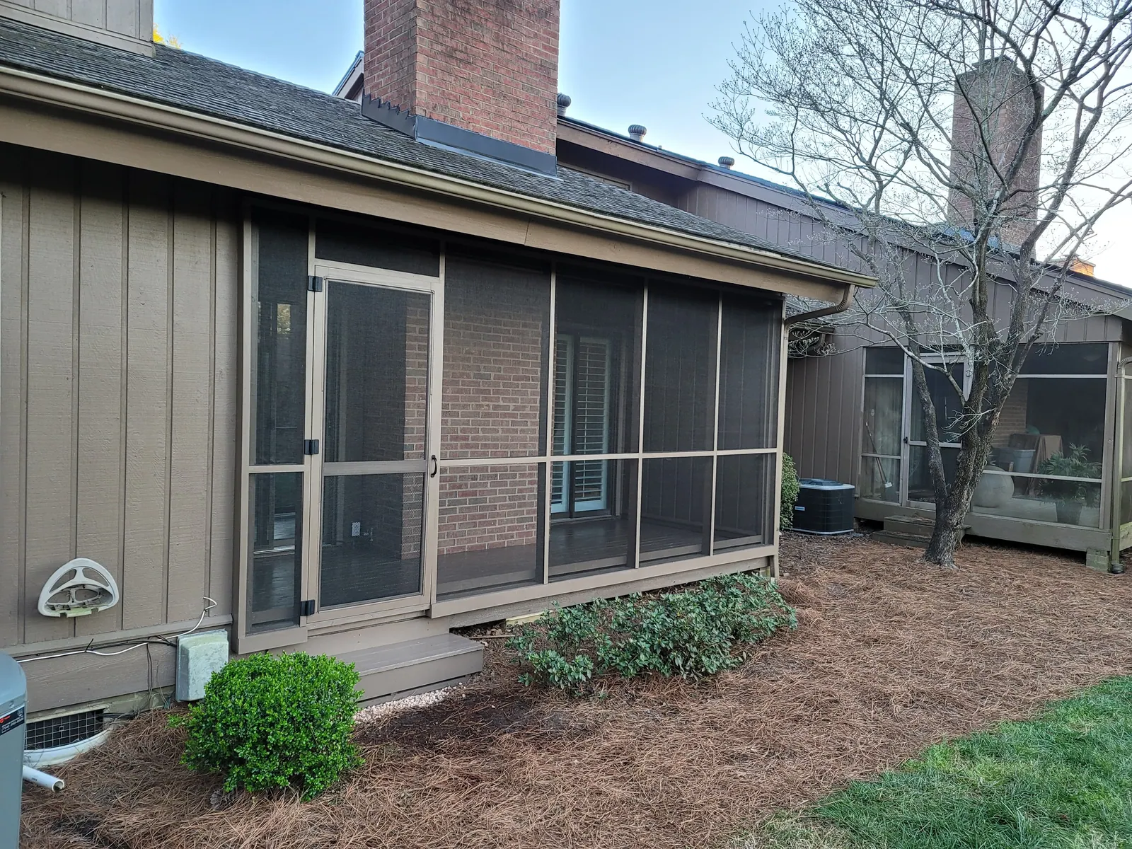 Back porch enclosed with screen panels and a screen door