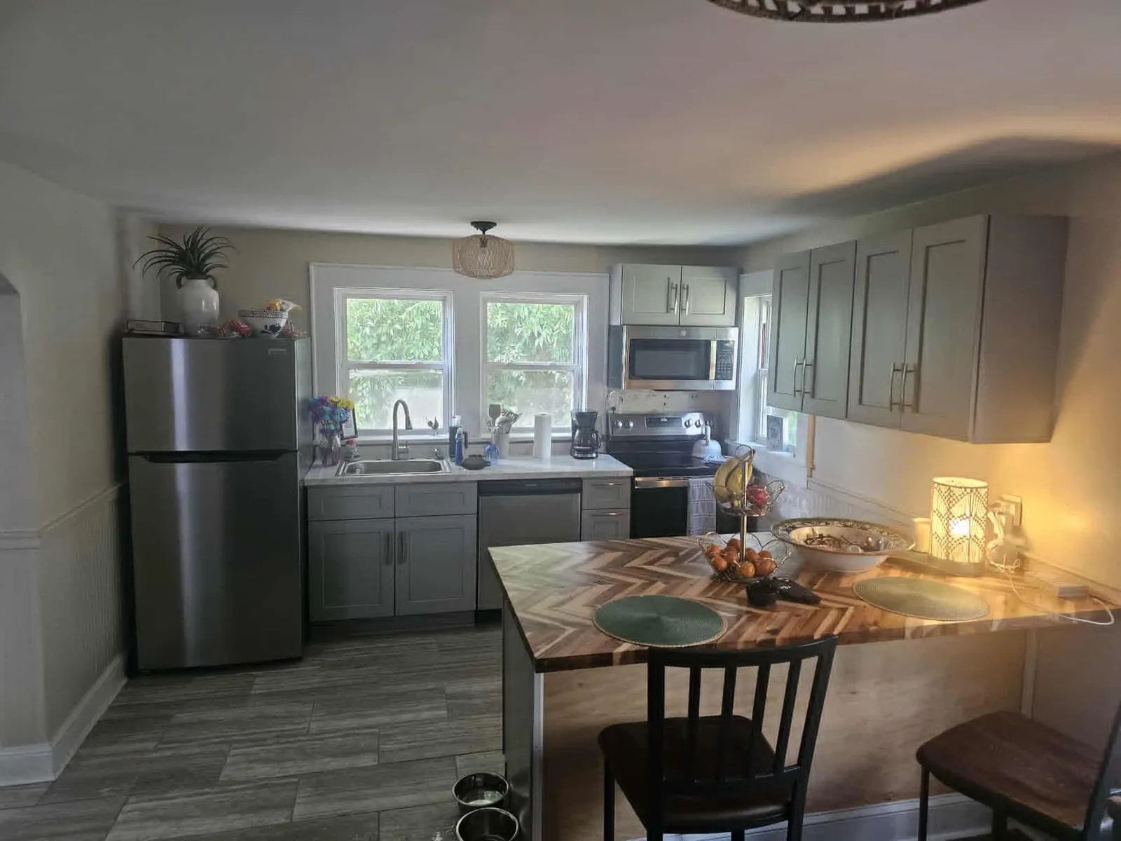 Kitchen with gray cabinets, stainless appliances and a butcher block peninsula