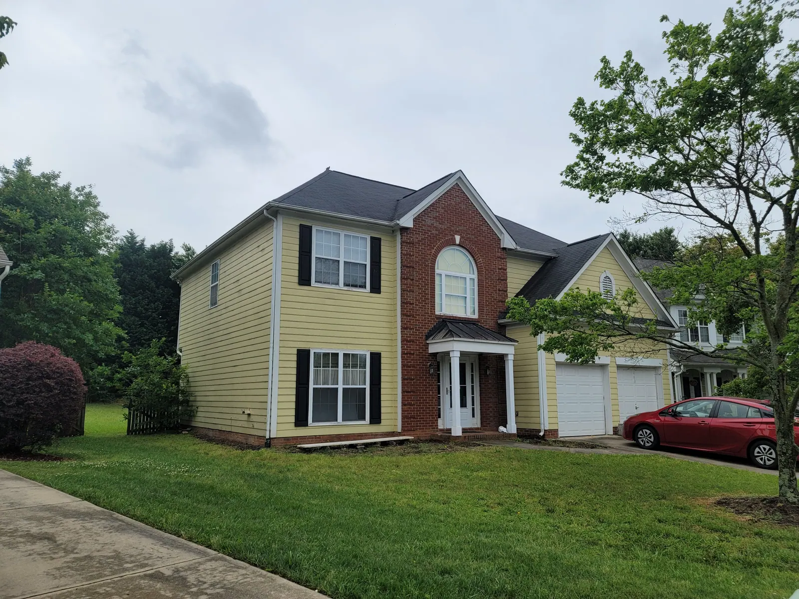 Front of a two-story home in yellow before its refresh